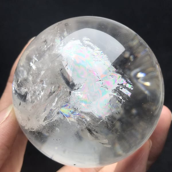 Iridescent rainbow sheet beside clear quartz and flakes