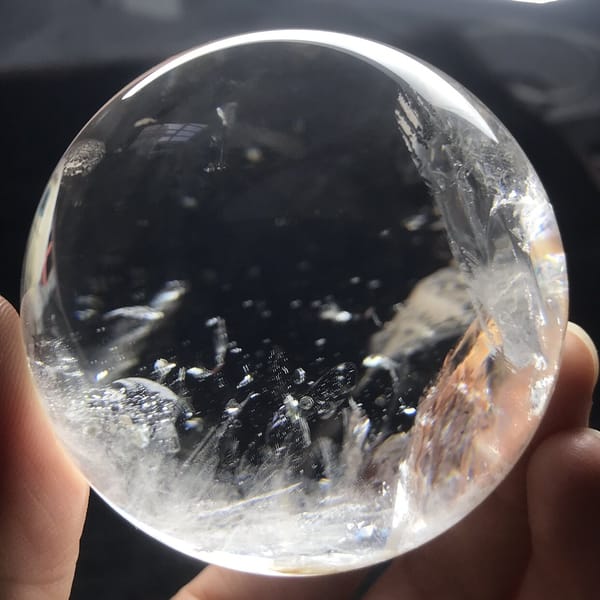 Clear sphere with mica flakes and feathery veils from the front
