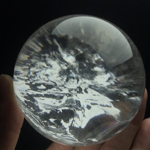 Mottled white inclusion clouds seen from the front of the quartz sphere