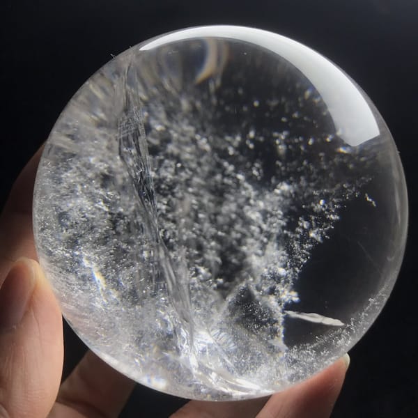 Diagonal spray of tiny white specks drifting through clear quartz