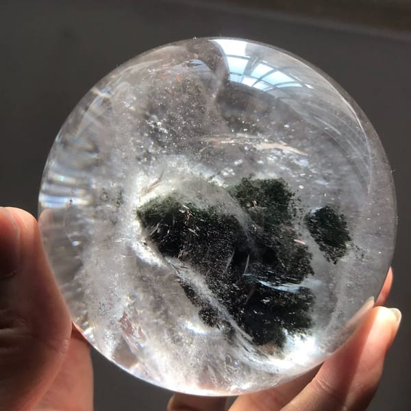 Green phantom mass tilted to the left inside the clear quartz sphere