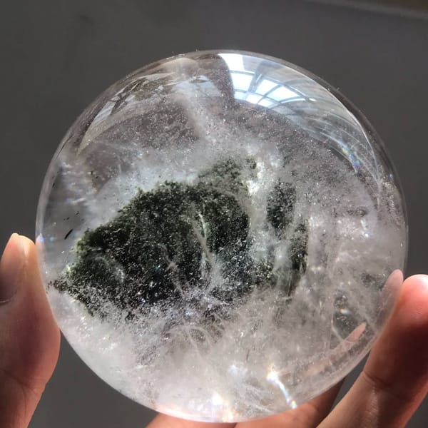 Wide green phantom spreading across the lower half of the polished sphere