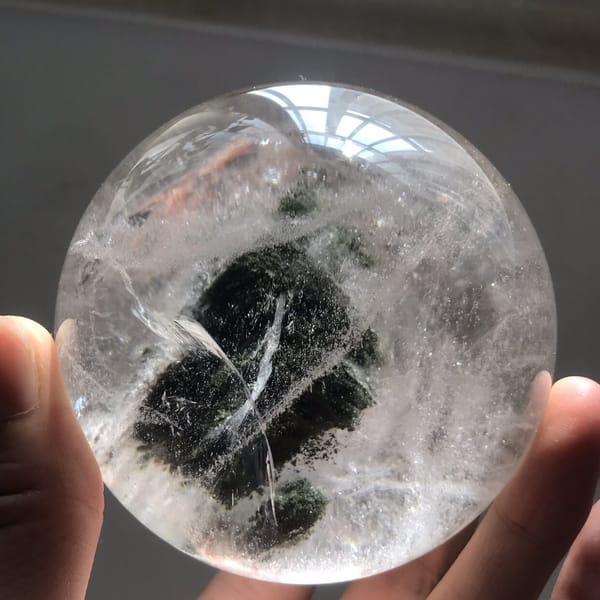 Diagonal green phantom crossed by white veil lines in the quartz ball