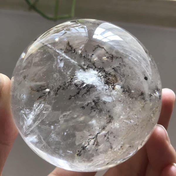 Tree-like inclusions branching around a central white tuft in the quartz