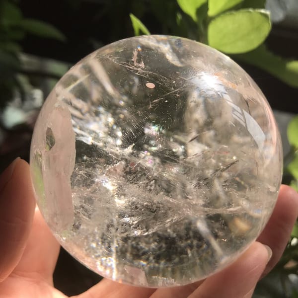Pale vertical veil and scattered sparkles on the reverse of the sphere
