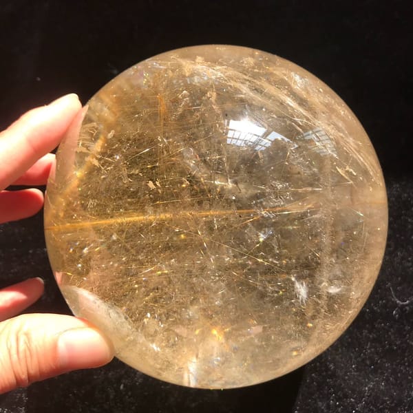 Long horizontal rutile needle across a field of fine golden threads