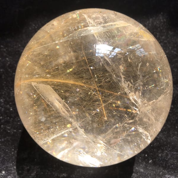 Rutile sphere from the side with a glassy veil plane at left