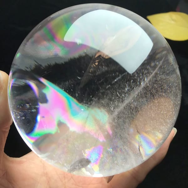 Broad pink and green rainbow sheet spreading across the lower sphere