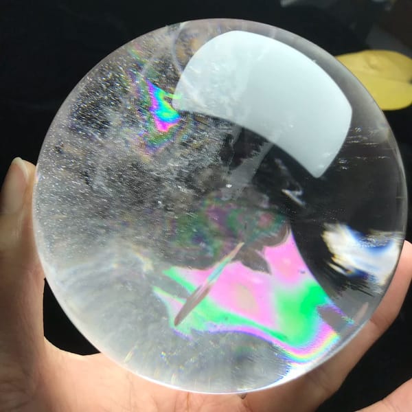 Pastel rainbow plane with a fine needle crossing it inside clear quartz