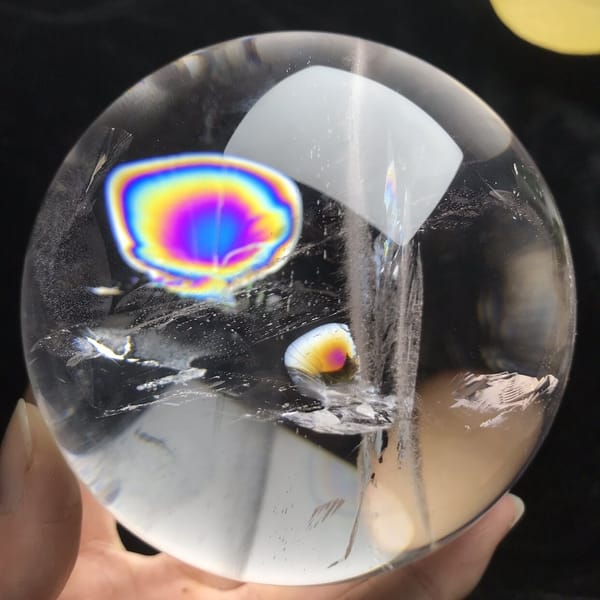 Large ringed rainbow disc beside a vertical veil line in the sphere