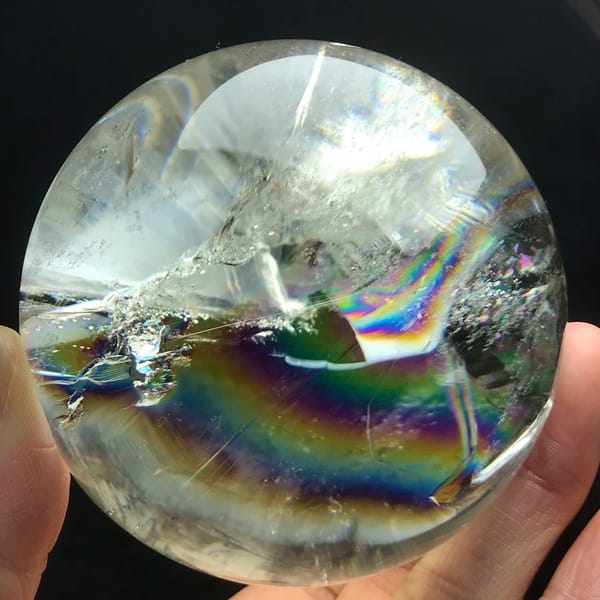 Horizontal rainbow arc with a dark crystal edge visible at centre