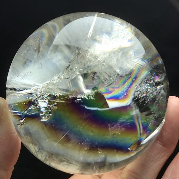Sharp-edged rainbow band glowing below glassy white inclusions