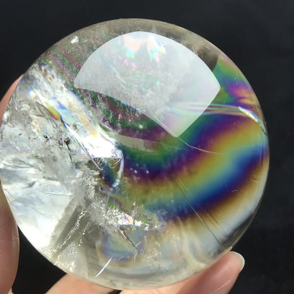 Bright rainbow arc framing the white inclusion patch on the left