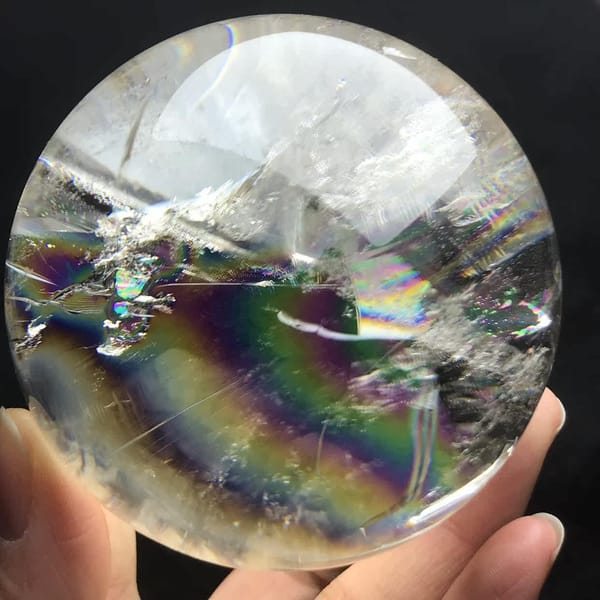 Rainbow band low in the sphere beneath clear glassy layers