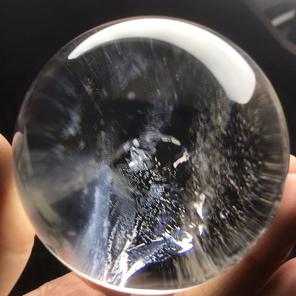 Blue-tinted cloud cluster at the centre of the polished sphere