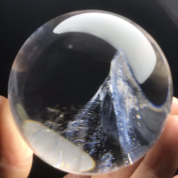 Wave-shaped blue inclusion peak beside a warm hand reflection