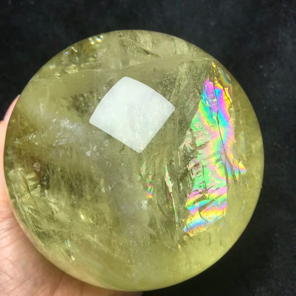 Upright rainbow curtain along the right side of the citrine sphere