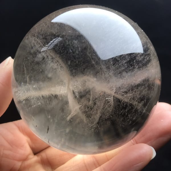 Fine fibrous wisps twisting through the pale smoky crystal