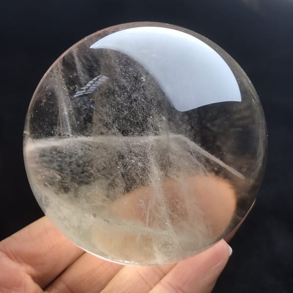 Veils crossing near the base of the polished smoky sphere