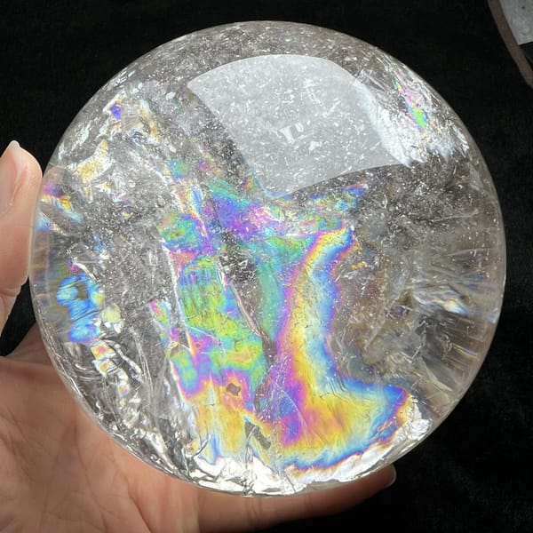 Rainbow with blue edges set among sparkling crackle in the quartz