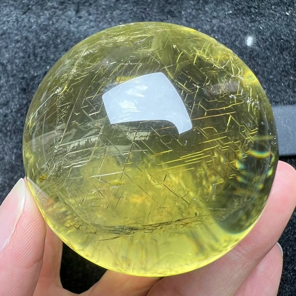 Network of straight golden lines etched through the clear citrine sphere