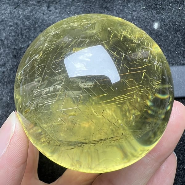 Rune-like patterns covering the upper half of the citrine sphere