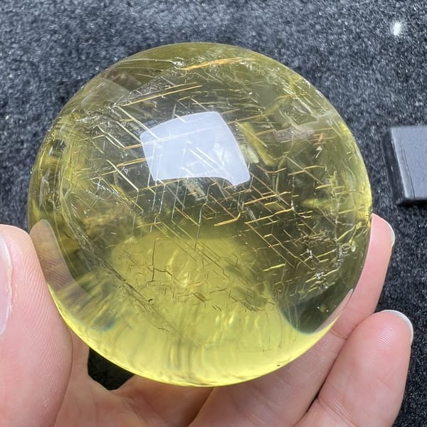 Golden net of lines across the face of the polished citrine