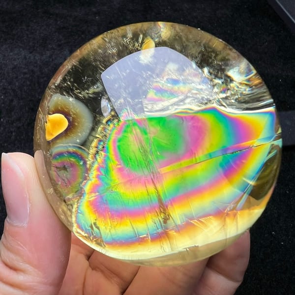 Rainbow rings rippling across the lower half of the golden citrine ball
