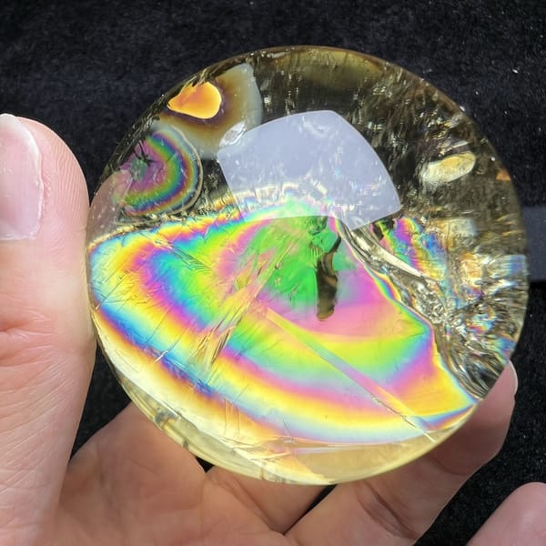 Full rainbow band arcing across the polished Brazilian citrine
