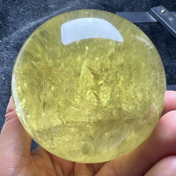 Upward fans of veils centred in the polished citrine sphere