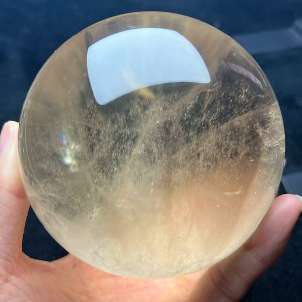 Champagne citrine ball with fine strands sweeping across the middle