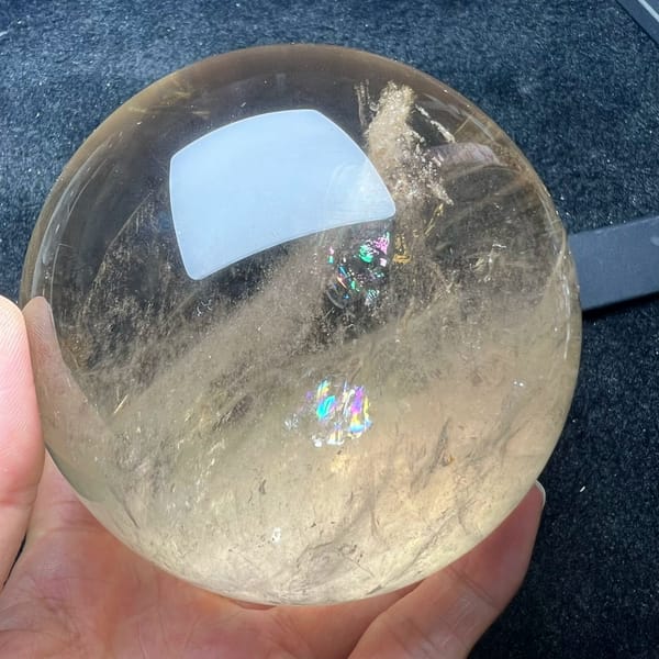 Two small rainbows sparkling at the right side of the citrine sphere