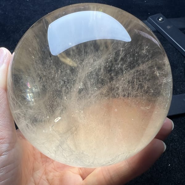 Citrine with warm gold base and fine wisps under the reflection
