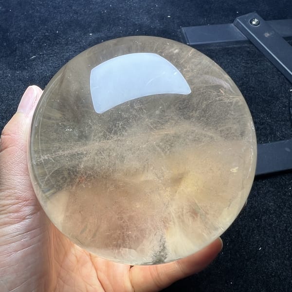 Soft yellow citrine sphere seen from a lower angle with wisps