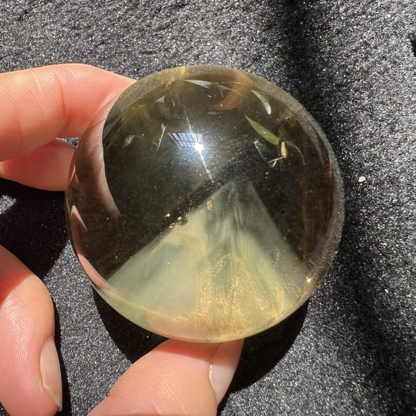 Citrine sphere on black cloth with the pyramid glowing below