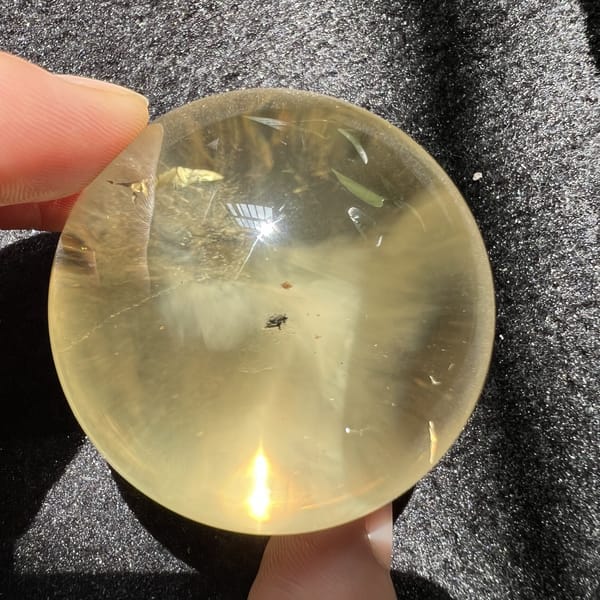 Pale golden citrine with a small dark speck and soft rays
