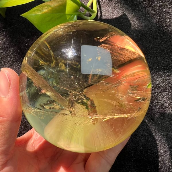 Citrine sphere with diagonal veils and amber light on the right