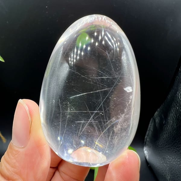 Polished quartz egg showing scattered white needles at many angles