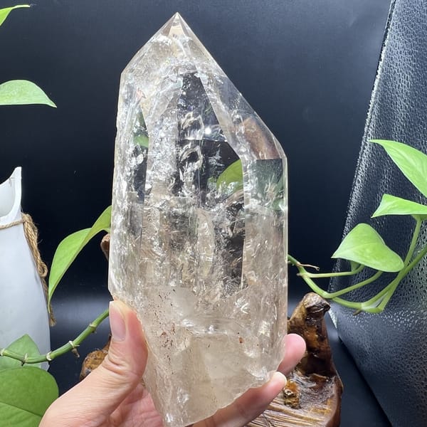 Quartz point held up with sparkling inclusions throughout