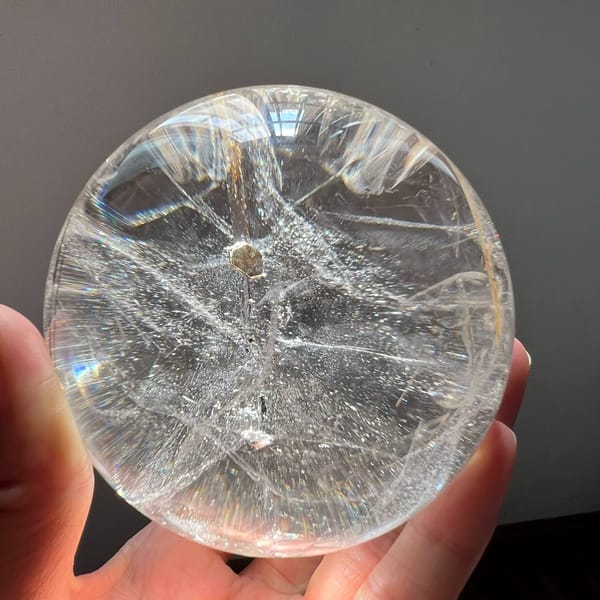 Coin-like mica flake with a string of glittering flakes trailing below
