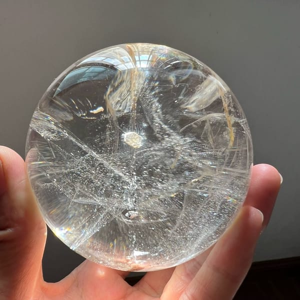 Sunlit quartz ball with starry glitter and the mica coin near the top