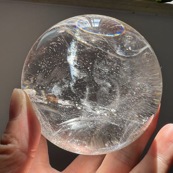 Rainbow at the rim of the sphere above a glittering vertical veil