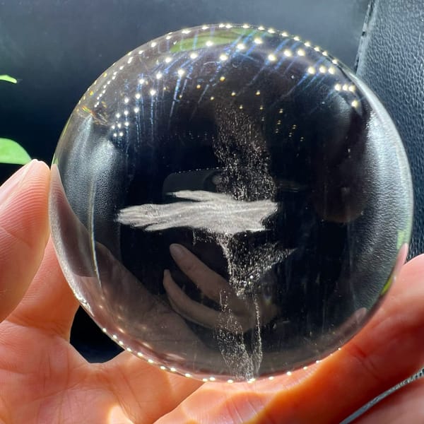 Horizontal white plume floating in the dark smoky quartz ball