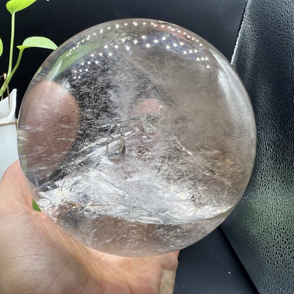 Large sphere turned to show its veil ridge and a pink hand reflection