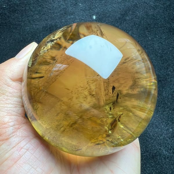 Even amber colour through the citrine sphere with faint veils deep inside