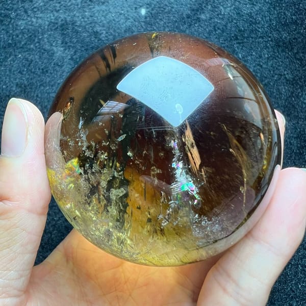 Rainbow flash beside a pale veil in the centre of the golden citrine