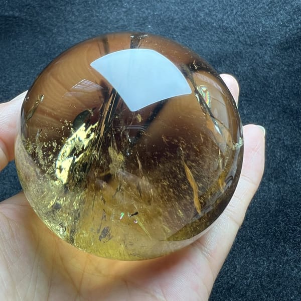 Clear yellow lower half of the sphere with a few gold feathers inside