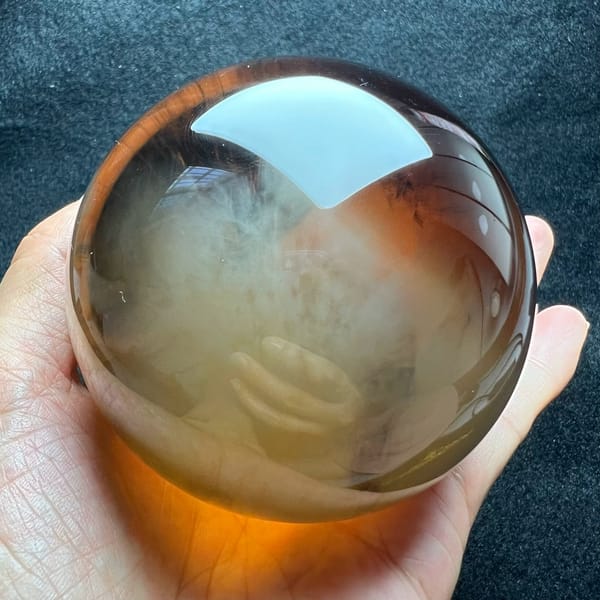 Honey-coloured sphere showing the white needle haze beneath the top reflection