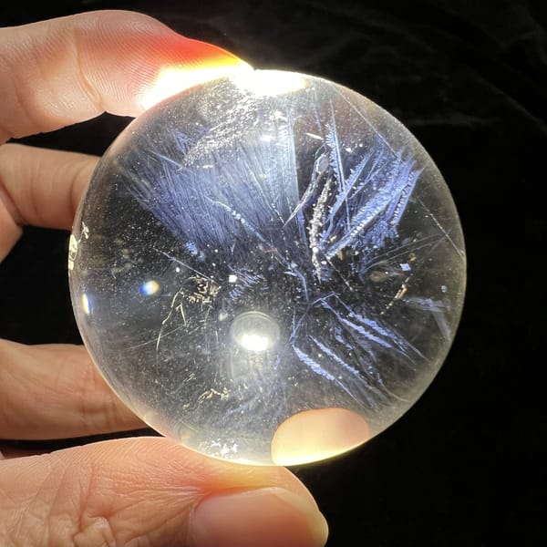 Wide fans of blue needles reaching toward both edges of the sphere