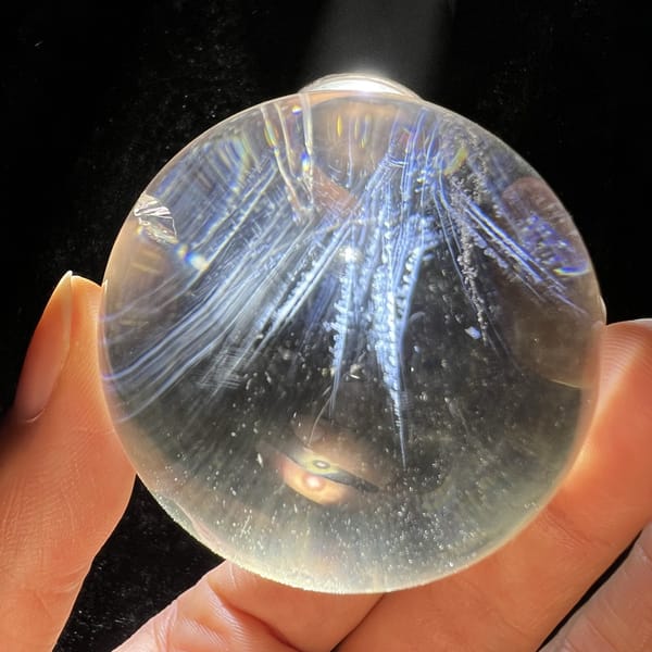 Long blue feather shapes viewed from the side of the polished sphere
